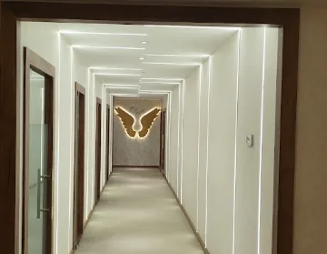 Brightly lit clinic corridor leading to an illuminated gold wings artwork